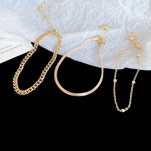 Detail of three-piece gold-plated bracelet set with Cuban, snake, and satellite chains