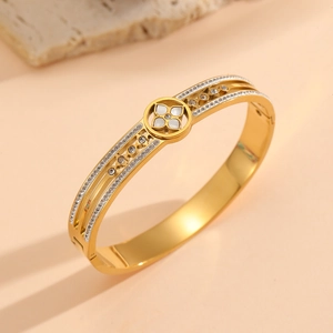Golden titanium steel bangle featuring shell clover and pavé diamonds on a natural stone