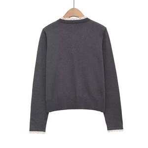 Pull en maille gris foncé avec bordure en dentelle blanche sur le col et les poignets