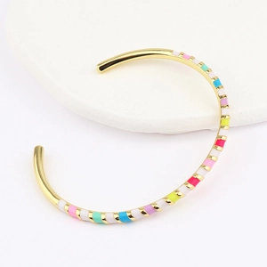 Macro detail of Bohemian colorful enamel bangle with gold-plated geometric pattern