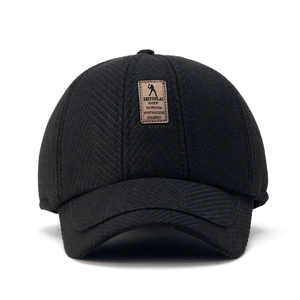 Detailed view of black textured herringbone baseball cap with a brown embossed leather patch
