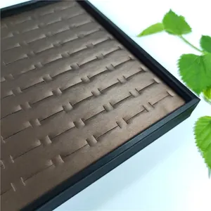 Macro shot of bronze brushed metal slots for 100-piece ring display tray and organizer