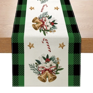 Polyester Christmas table runner with bells and holly pattern on a wooden dining table