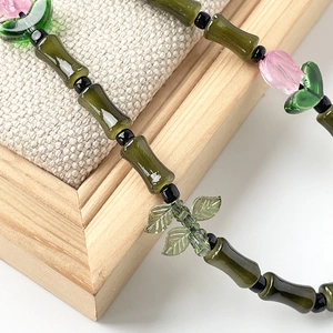Green glass bamboo joint and pink tulip flower bead phone strap with leaf charm