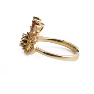 Close-up detail of golden adjustable ring set with colorful zircons in a channel setting
