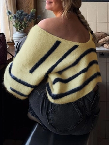 Detail shot of a women's striped knit sweater showing the backless off-shoulder design
