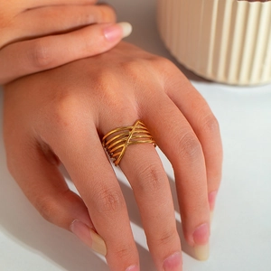 Crossed multi-layer gold stainless steel ring displayed on a model hand