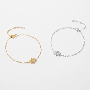 Close-up of silver and gold hexagram star bracelets with sparkling zircon stones