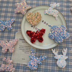 Detail of colorful sequined fabric patches in star, heart and flower shapes for crafts