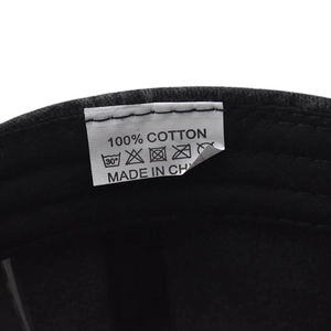 Macro shot of 100% cotton wash label and care instructions inside a washed baseball cap