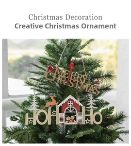 Detail of wooden Merry Christmas and Ho Ho Ho hanging ornaments on a green festive tree