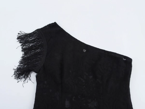 Detail showing elegant black lace fabric with fringed tassel trim on the shoulder