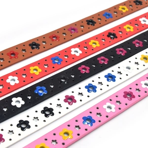 Flat lay of colorful PU leather belts featuring floral eyelets and alloy pin buckles