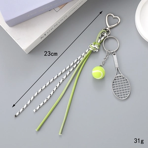 Detail view of mini tennis racket keychain with neon ball and woven rope accents