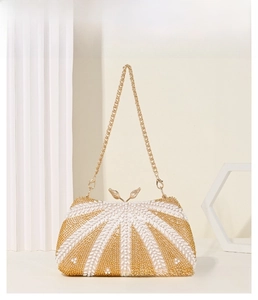 Detail of sequin evening bag with gold bird clasp and elegant chain strap