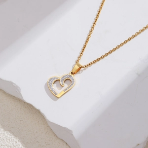 Detail of 18k gold heart pendant with white enamel and sparkling crystal stones