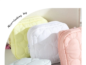 Close-up of quilted cream-colored cloud storage bags with soft macaron pastel textures