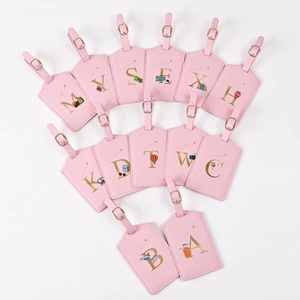 Pink PU leather luggage tags with gold initial letters and travel theme illustrations