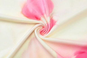 Vue macro d'un tricot tie-dye rose et crème avec un détail de texture en spirale