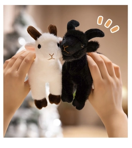 Close-up of cute black and white plush sheep charms with holiday lights background