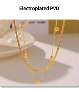 Detail of PVD plated double layer gold heart necklace with snake chain and heart pendants