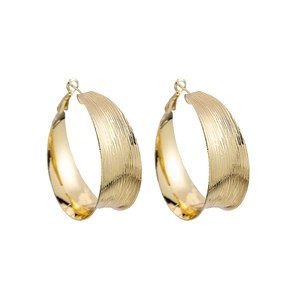 Golden C-shaped large hoop earrings with a modern brushed texture on white background