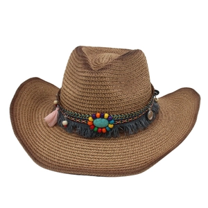 Detail of bohemian western straw hat with turquoise beads and fringe tassels