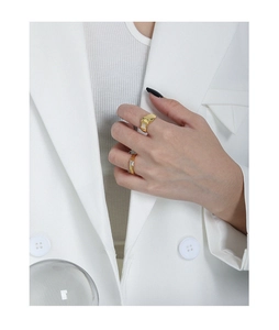 Detail of minimalist gold-plated geometric ring and micro-set zircon band on hand