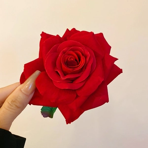 Detailed view of a handmade red fabric rose hair claw clip with realistic velvet petals