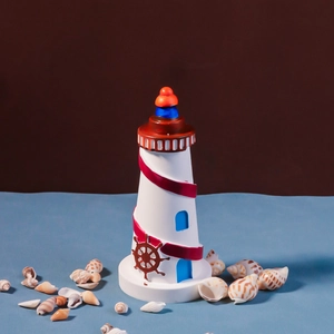 Mediterranean resin lighthouse ornament with red spiral and blue window on seashells