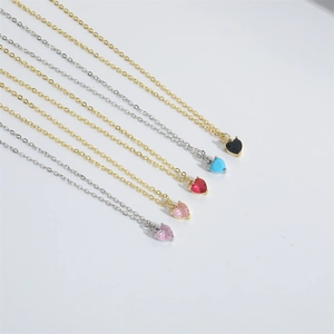 Close-up of five colorful heart-shaped zircon pendants on elegant gold and silver chains