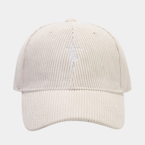 Détail de la broderie blanche sur le tissu en velours côtelé crème de la casquette