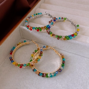 Detailed view of gold and silver hoop earrings with multicolored faceted crystal beads
