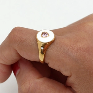Détail de la bague en or 18 carats avec gemme cœur rose sur disque blanc