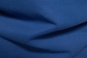 Close-up of deep blue cotton polo shirt fabric showing breathable piqué weave texture