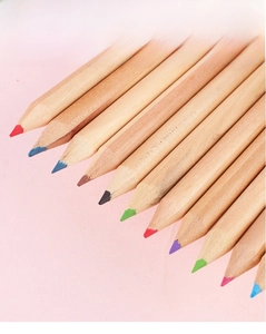 Close-up of 12 vibrant colored pencils with natural wood finish on a pink background