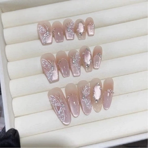 Fairy butterfly press-on nails set with pink cat eye effect and 3D pearls on velvet tray