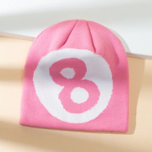 Pink knitted beanie with white circular patch and number 8 graphic on a neutral background