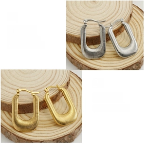Detail of 18K gold and silver U-shaped earrings featuring a vertical striped texture