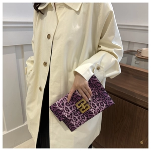 Detailed view of a purple leopard print envelope clutch with gold metal buckle