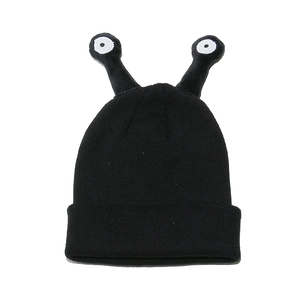 Detailed knit texture of a black funny beanie with cartoon eye tentacles on top