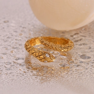 Macro shot of gold-plated snake ring with scale texture and a white sparkling zircon