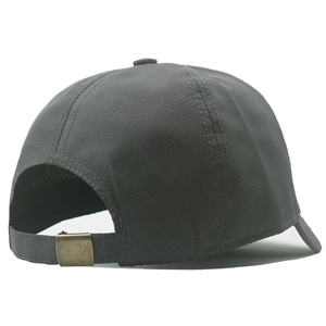 Close-up of the vintage copper metal buckle on a dark grey honeycomb texture baseball cap