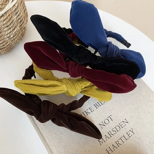 Velvet knotted headbands in navy, black, red, yellow, and coffee brown on a book