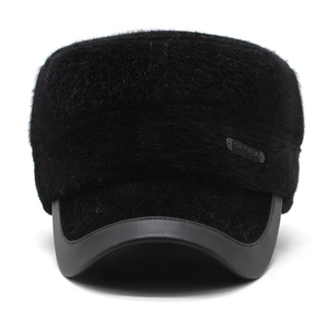 Close-up of winter flat top cap featuring thick black faux fur and metal brand plaque