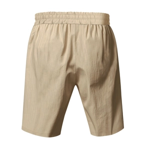 Detail showing khaki lightweight linen texture and elastic waistband of casual beach shorts