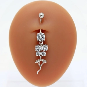 Detail of silver heart bow belly ring with round crystals on silicone navel model