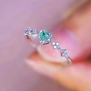 Exquisite women's silver ring with a green gemstone and diamond-paved heart design