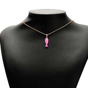 Detailed view of a gold-tone fish pendant with pink enamel on a black mannequin