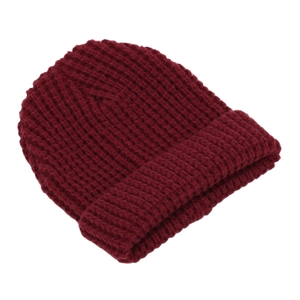 Macro detail of the dark red thick knit texture and folded cuff on a warm winter beanie